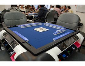 自動配牌式の最新型麻雀卓。白と黒の枠に青が映えます。